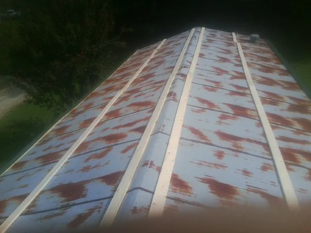 Rusted metal roof panels with new wood purlins before replacement — Storm Damage Roof Repair in Hamer by Roofing Brothers