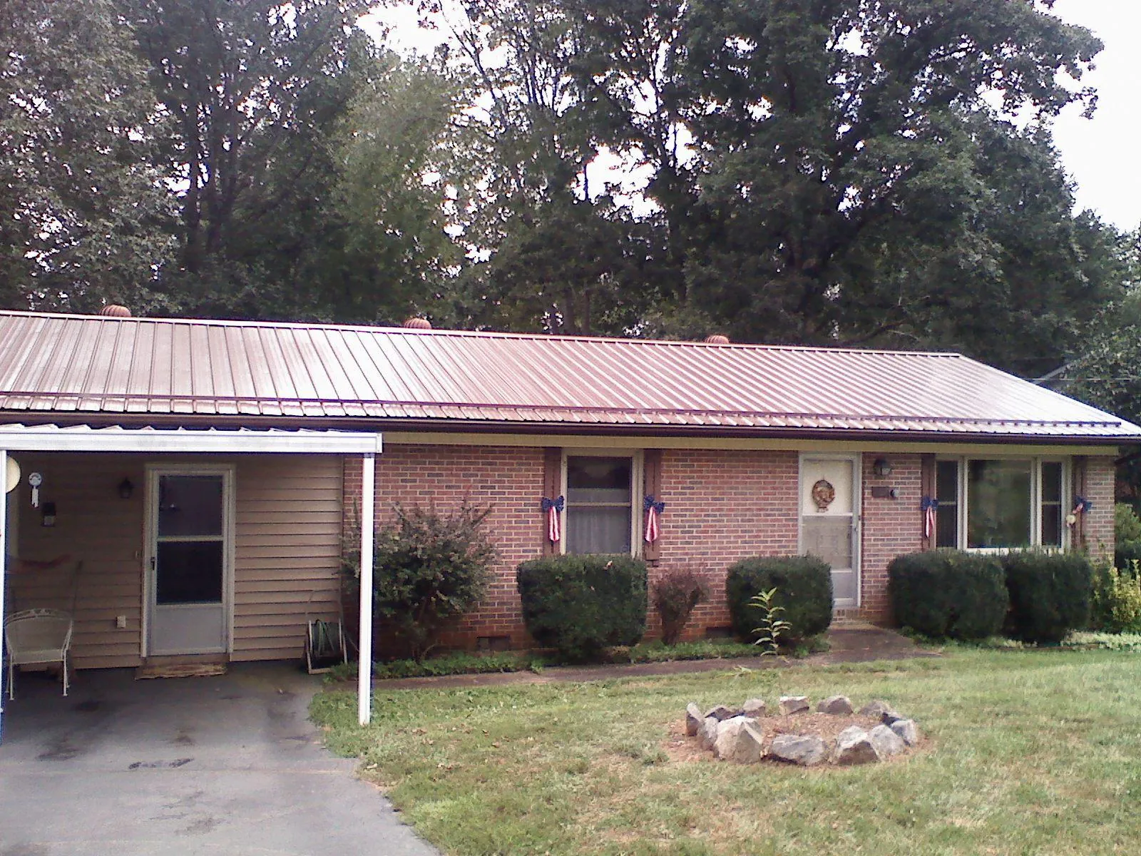 Bronze metal roof and carport on a brick ranch home — Roof Repair work by our crew in Hamer