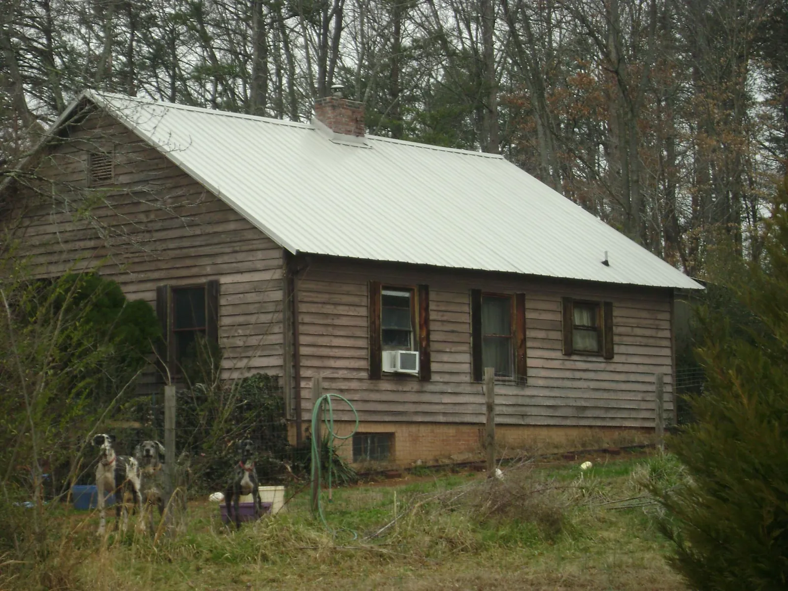 White metal roof on an old wood sided farmhouse, from a Metal Roof Installation job in Hamer